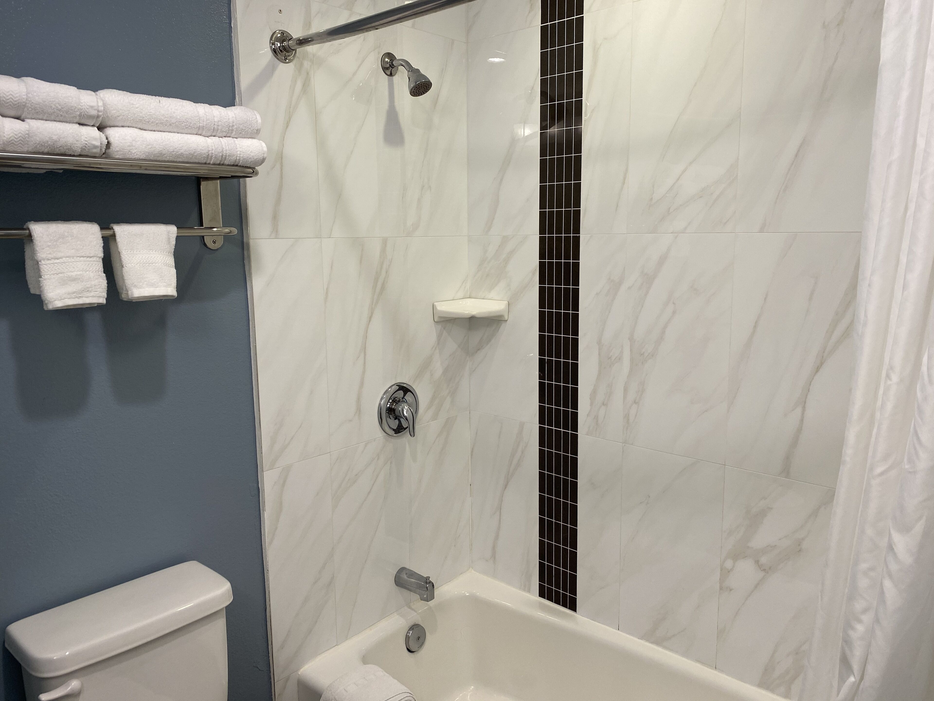 Une salle de bain équipée d’une baignoire, de toilettes et d’un porte-serviettes avec des serviettes.