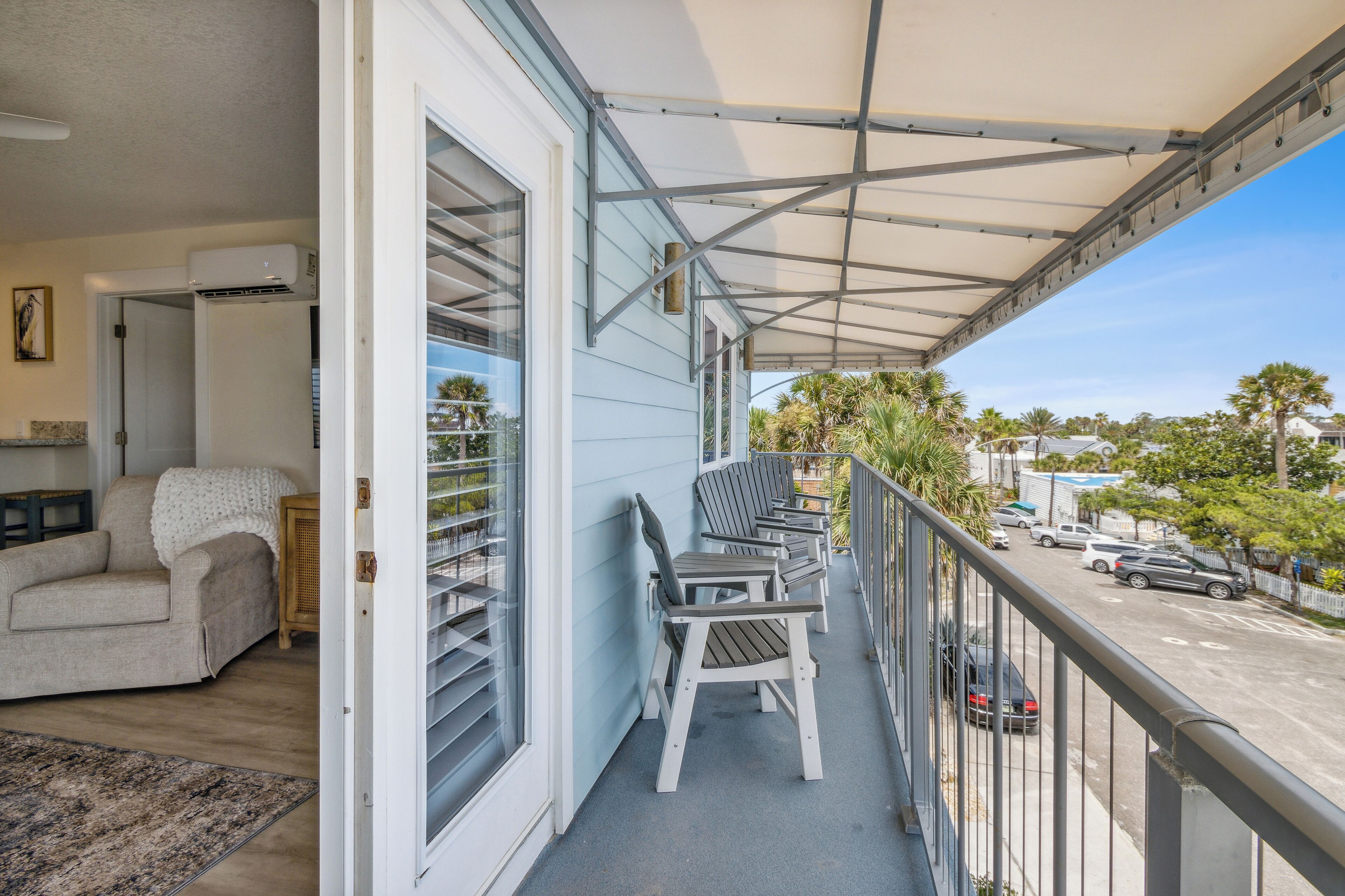 Un balcon doté d’un espace couvert, d’un canapé et d’une table à manger avec des chaises.