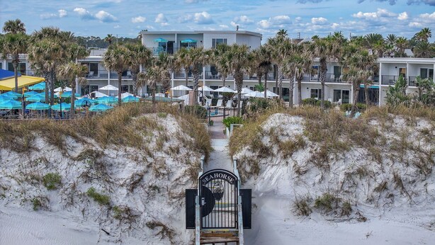 A pathway leading to a gated entrance with a sign reading "FEAHORSE." - Seahorse Oceanfront Inn (Neptune Beach)