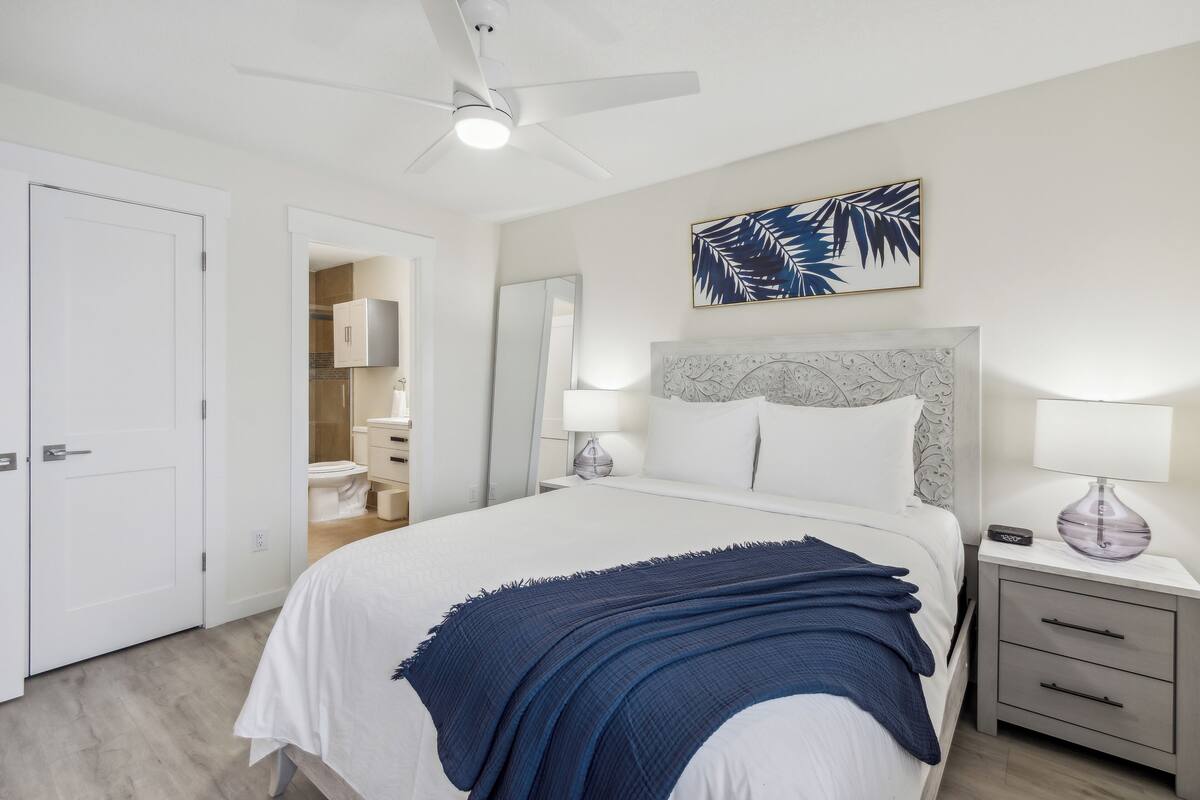 A bedroom with a bed, nightstand, and a ceiling fan.