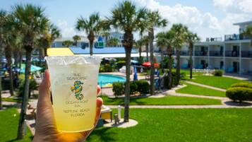 Una mano sosteniendo una bebida con una etiqueta que dice 'The Seahorses Oceanfront Inn Neptune Beach, Florida'.