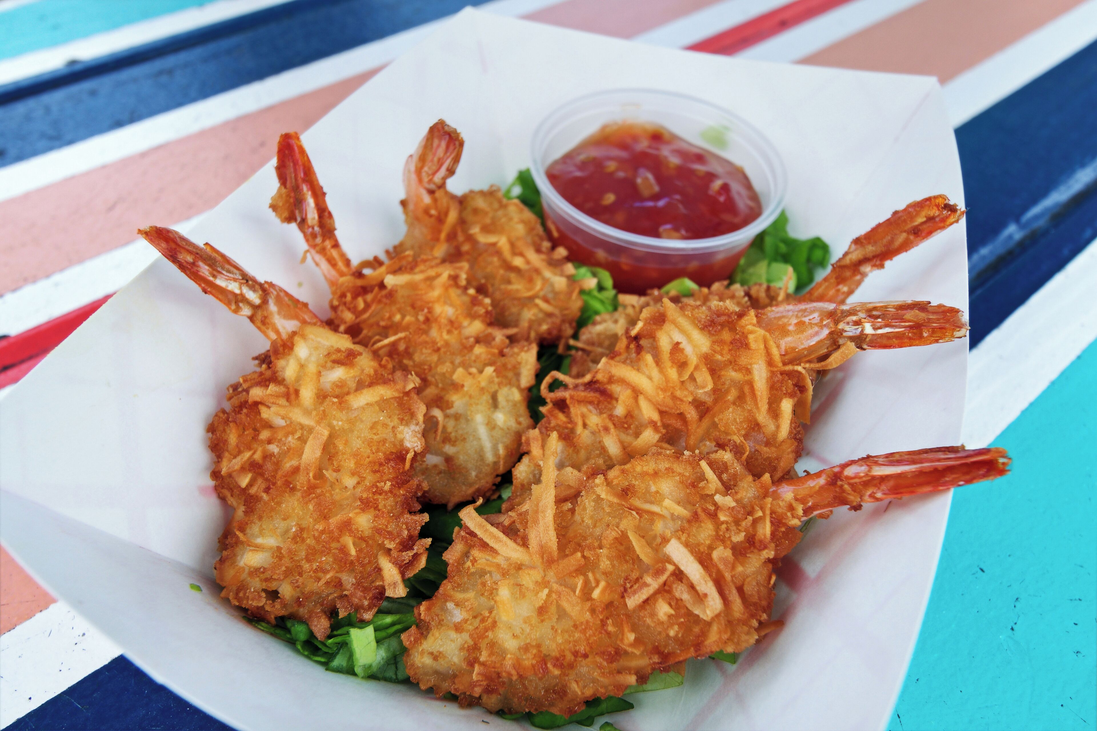 Un piatto di gamberi fritti serviti con salsa ketchup.