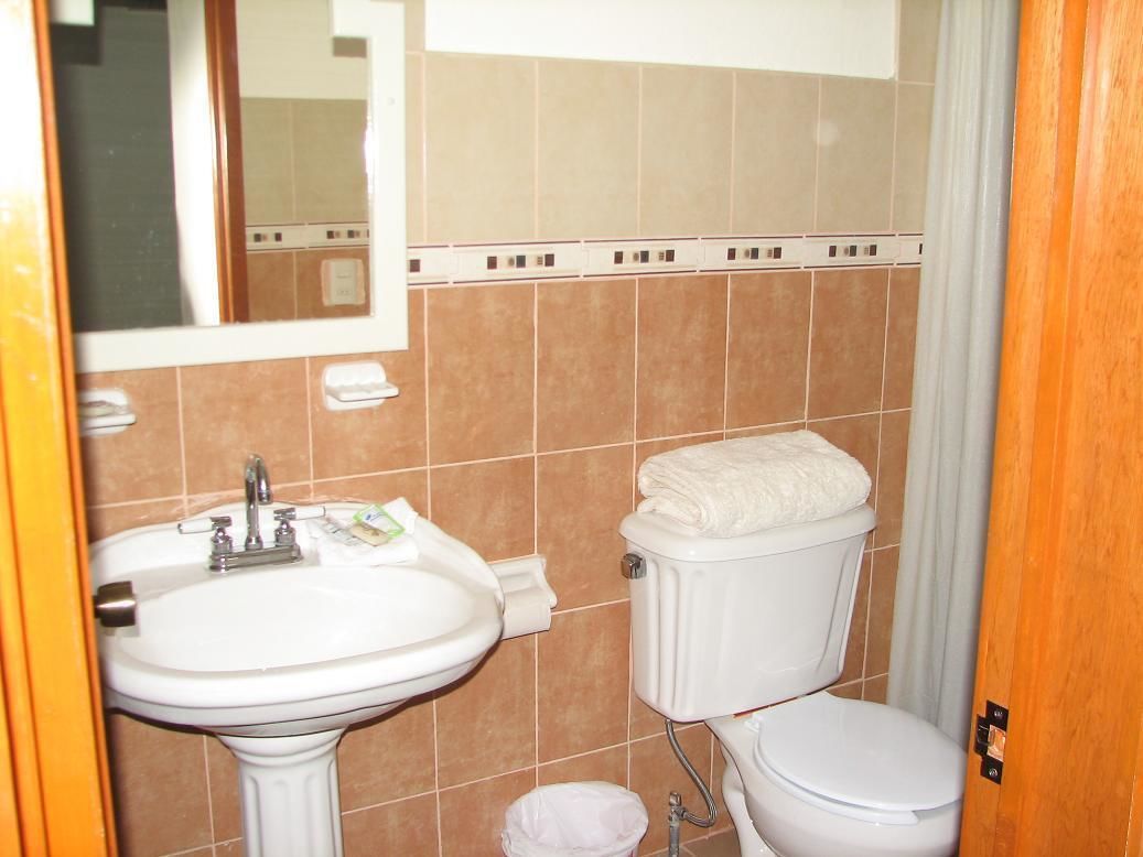 Un bagno con lavandino, WC e specchio.