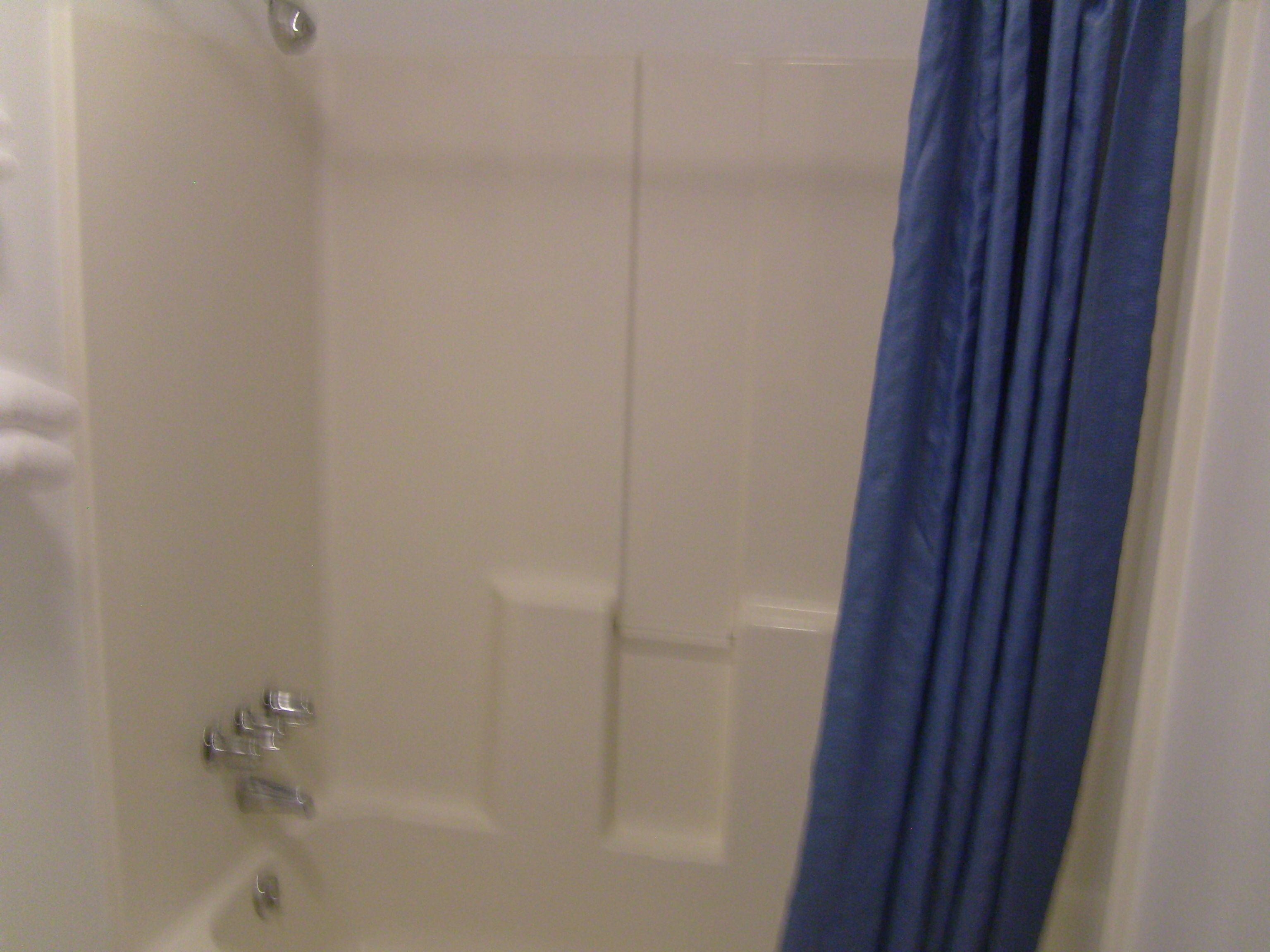 Een badkamer met een bad, douche en toilet.