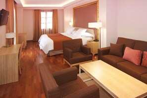 A hotel room with a bed, two sofas, a coffee table, a TV, and a desk. - Hotel Casa Consistorial (Fuengirola)