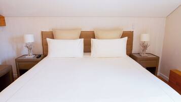 Una habitación de hotel con una cama grande, dos mesitas de noche y lámparas.