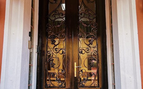 A double wooden door with intricate ironwork.