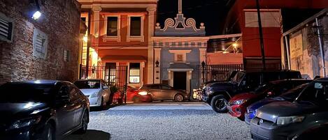 A parking lot with several cars and a building with a cross on the facade.