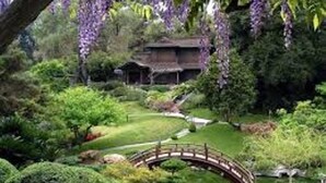 A traditional Japanese-style building surrounded by lush greenery and a small bridge. - Inland Suites Lamar Street (Memphis)