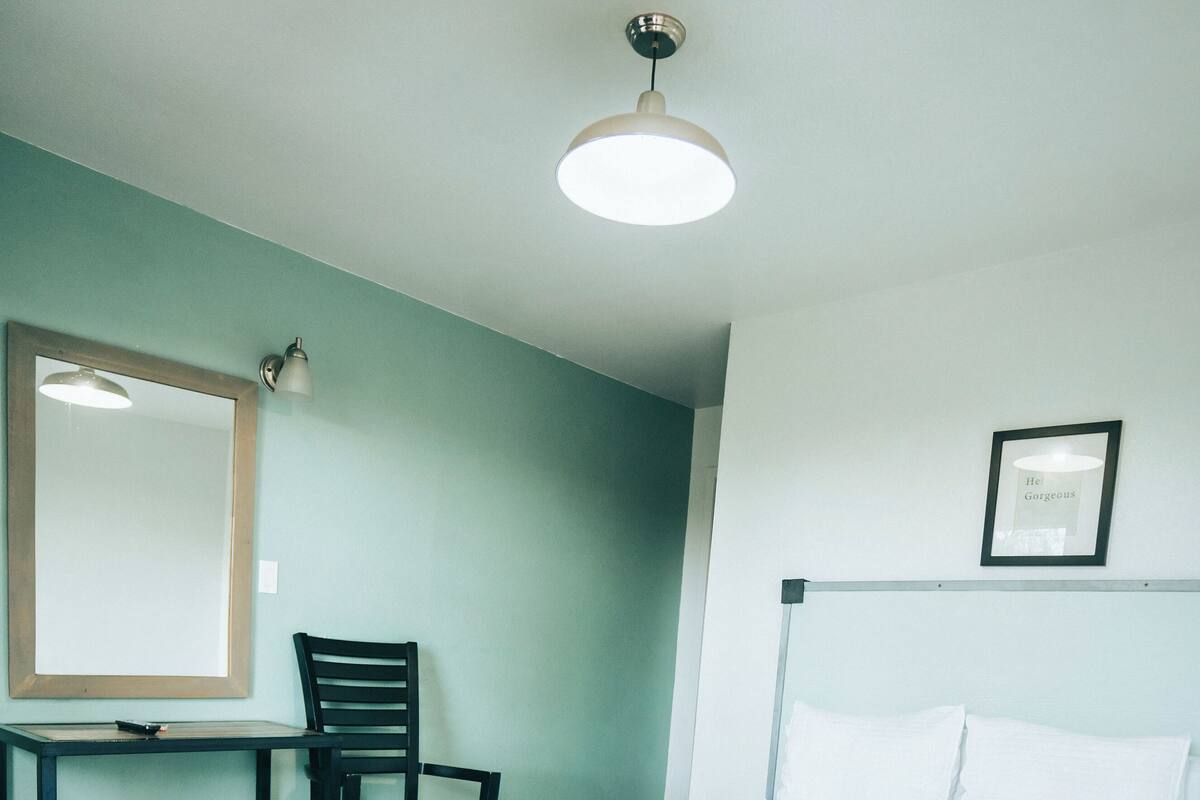 Ein ordentlich eingerichtetes Schlafzimmer mit Bett, Schreibtisch und Stuhl.