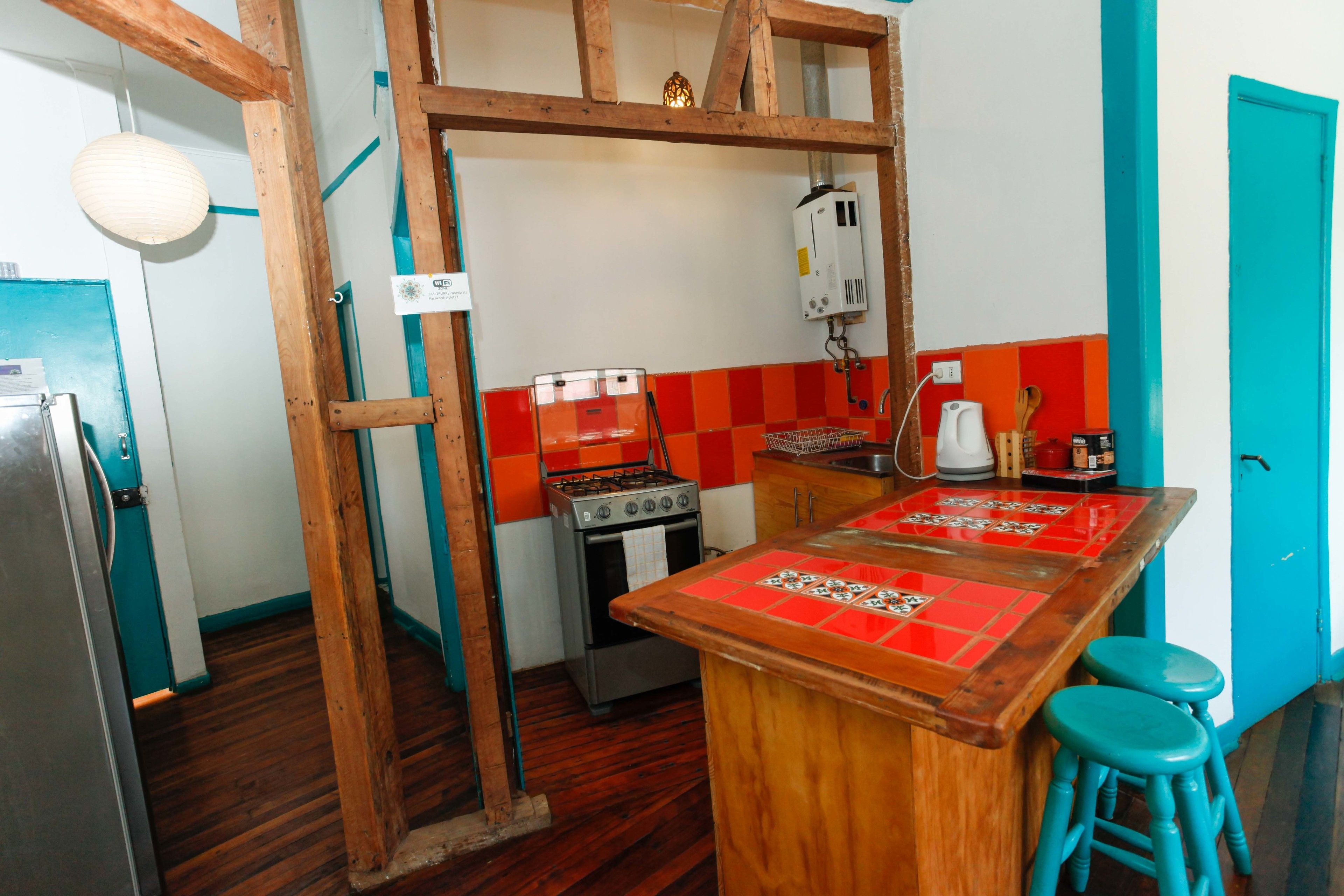 Una cocina con una isla de madera, una estufa a gas y un refrigerador.