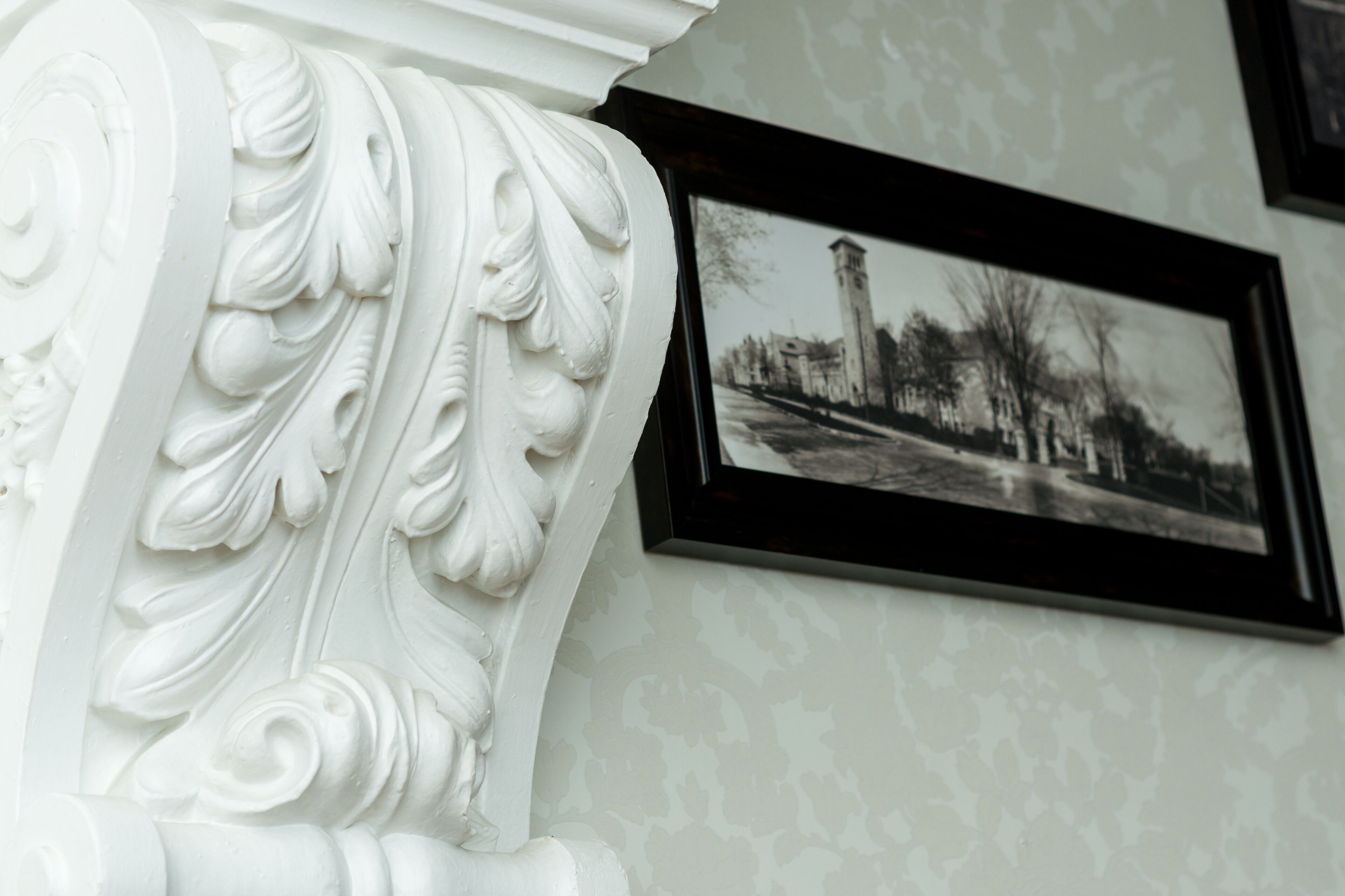 A white architectural detail with a framed black-and-white photograph on the wall.