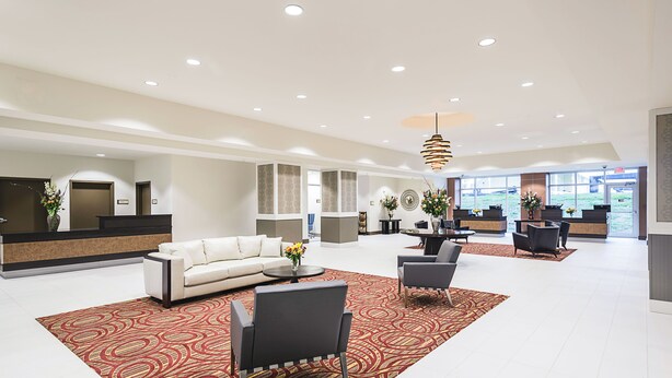 A spacious lobby with a reception desk, a sofa, and seating area. - Boomtown Casino & Hotel New Orleans (Harvey)