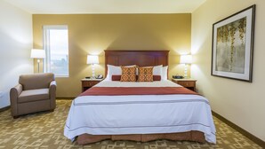 A hotel room with a large bed, two bedside tables with lamps, a chair, and a window. - Boomtown Casino & Hotel New Orleans (Harvey)
