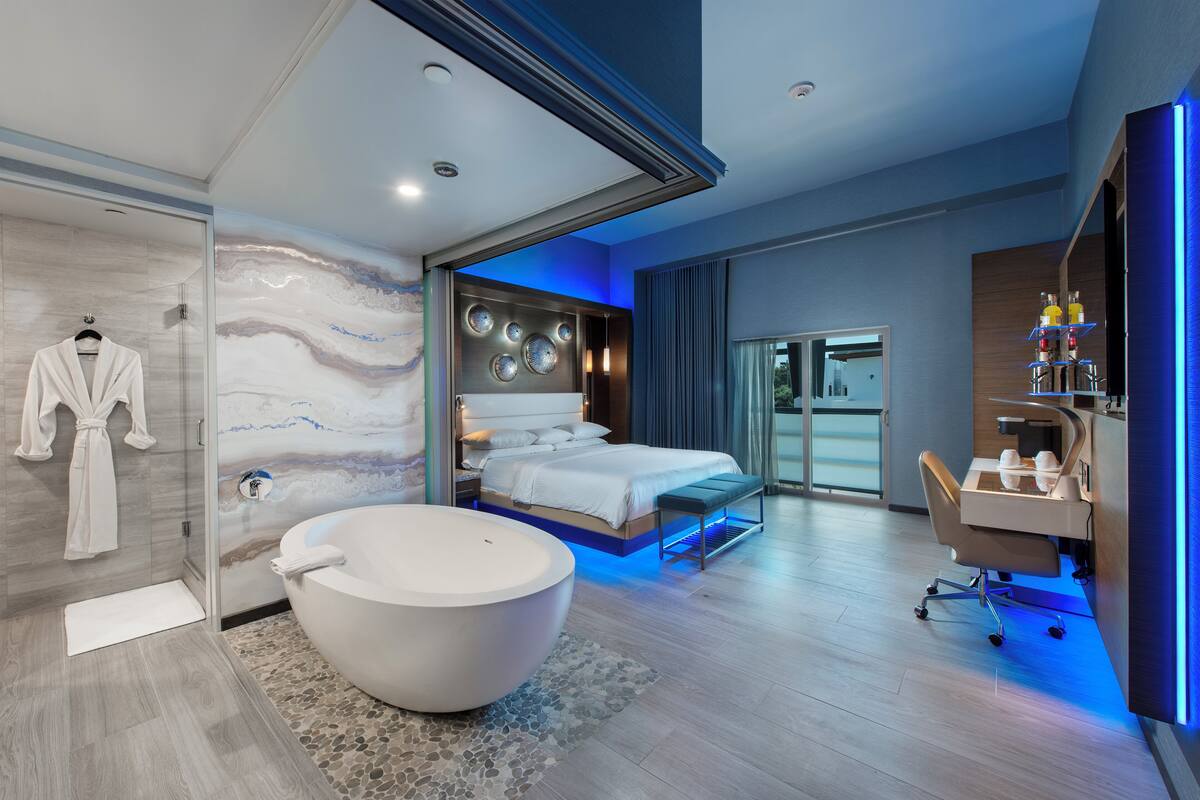 A modern bathroom with a large bathtub, a walk-in shower, and a glass-enclosed shower area.