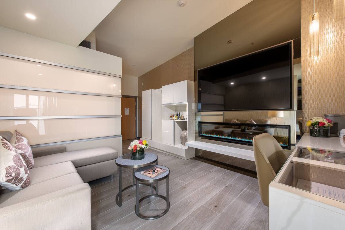 A modern living room with a sofa, a coffee table, and a flat-screen TV.