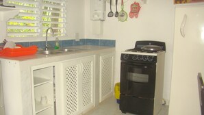 Uma cozinha com fogão, pia e armários.