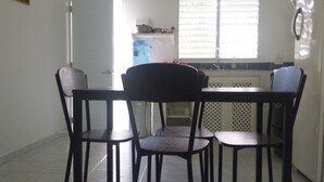 Uma sala de jantar com uma mesa e quatro cadeiras.