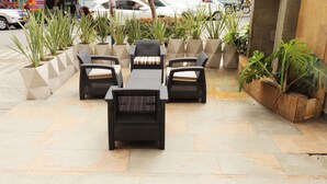 An outdoor seating area with wicker furniture and planters. - Hotel Lleras 10 (Medellín)
