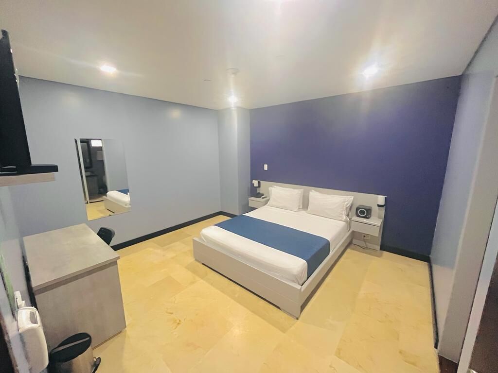 Una camera da letto con un letto, comodini, uno specchio e una scrivania.