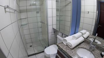 A bathroom with a glass-enclosed shower, a toilet, a sink, and a mirror.
