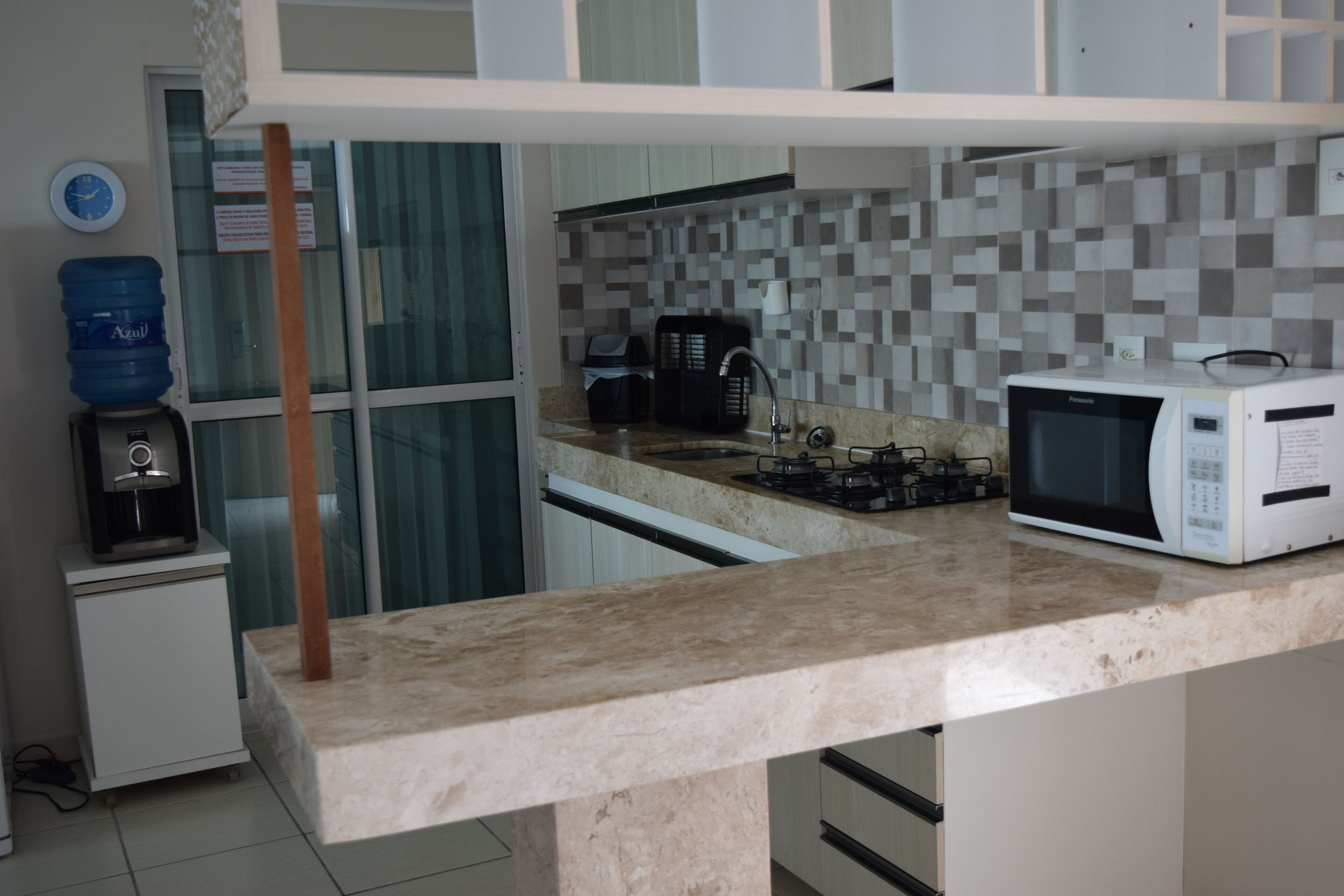 A kitchen with a microwave, coffee maker, and water dispenser.