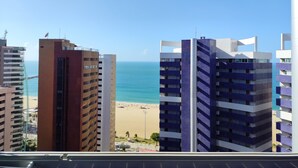 A view of a beach with high-rise buildings in the background. - Vip Beira Mar Residence (Fortaleza)
