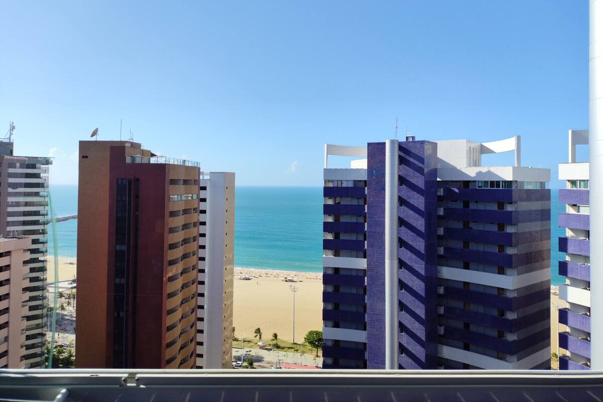 A view of a beach with high-rise buildings in the background.