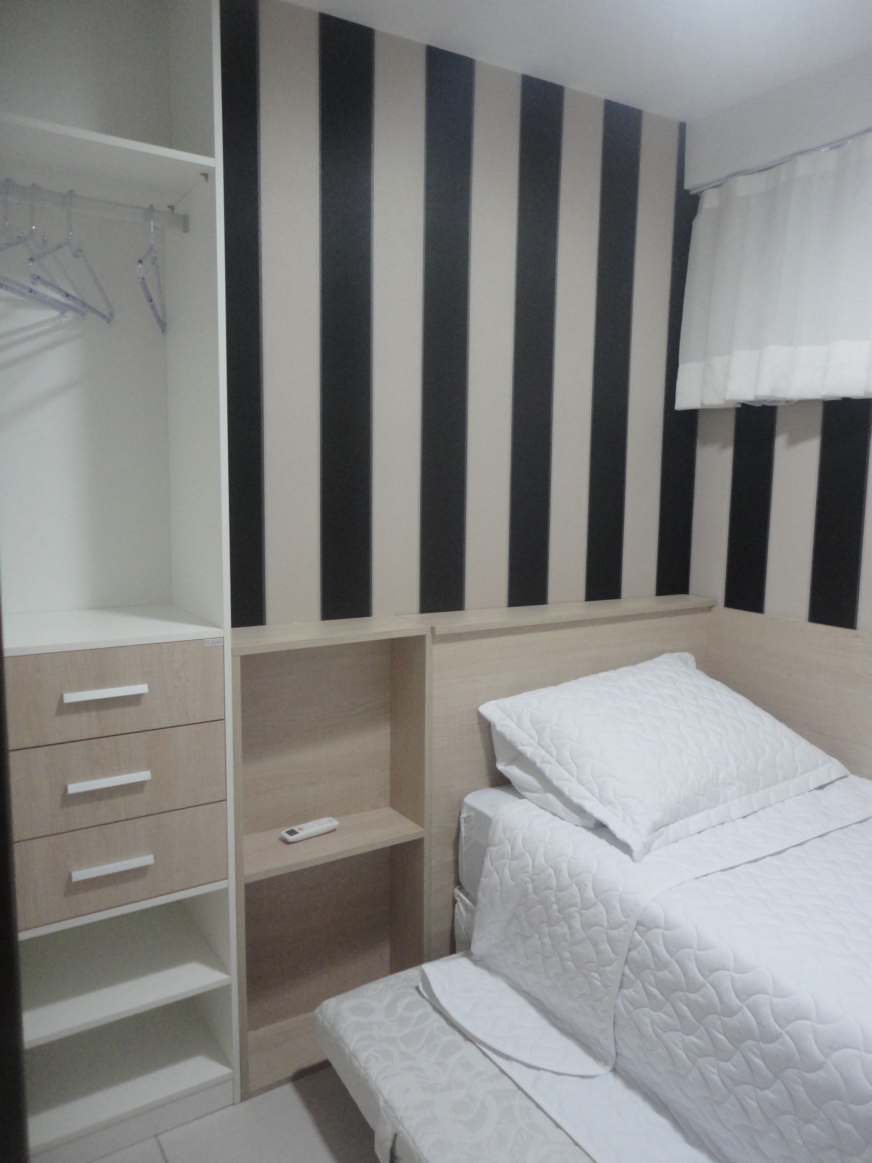 Une chambre à coucher comprenant un lit, une armoire et une étagère.