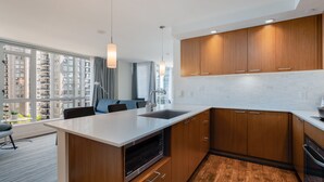 Eine moderne Küche mit Holzschränken, einer weißen Arbeitsplatte und einem eingebauten Backofen.