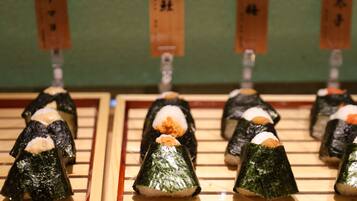Sushi arranged on wooden trays with labels.