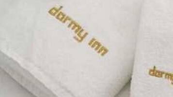 A stack of white towels with gold lettering.