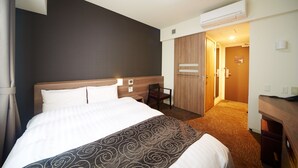 A hotel room with a large bed, a desk, a chair, and an air conditioning unit. - Dormy Inn Premium Nagoya Sakae Natural Hot Spring (Nagoya)
