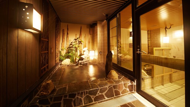 A traditional Japanese-style interior with a stone-tiled floor, wooden walls, and a glass door leading to a bathroom. - Dormy Inn Premium Nagoya Sakae Natural Hot Spring (Nagoya)
