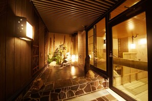 A traditional Japanese-style interior with a stone-tiled floor, wooden walls, and a glass door leading to a bathroom. - Dormy Inn Premium Nagoya Sakae Natural Hot Spring (Nagoya)