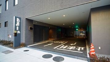 A parking garage entrance with directional arrows and a wheelchair-accessible path.