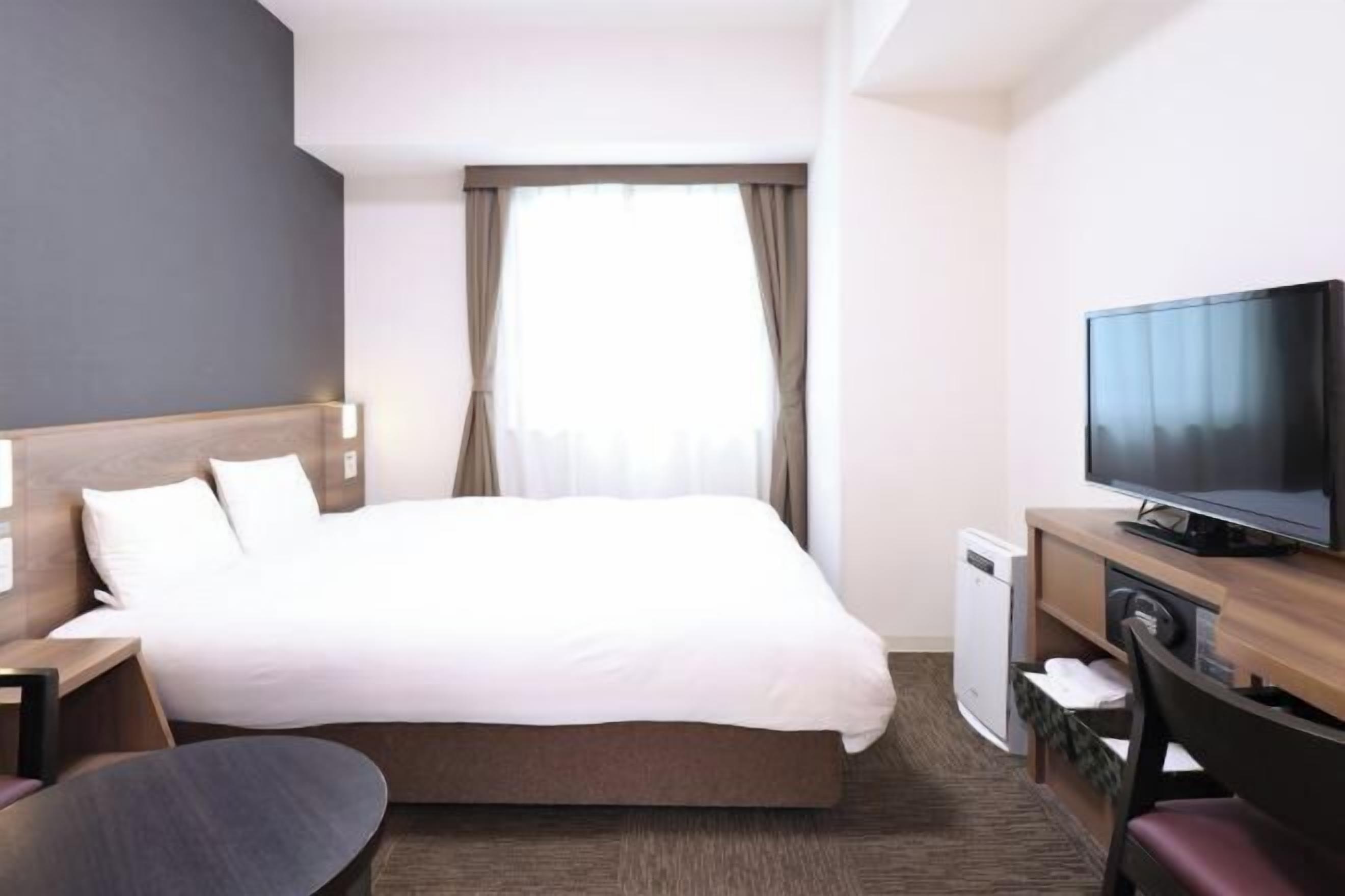 Ylelliset vuodevaatteet, untuvapeitot, tallelokero huoneessa, työpöytä