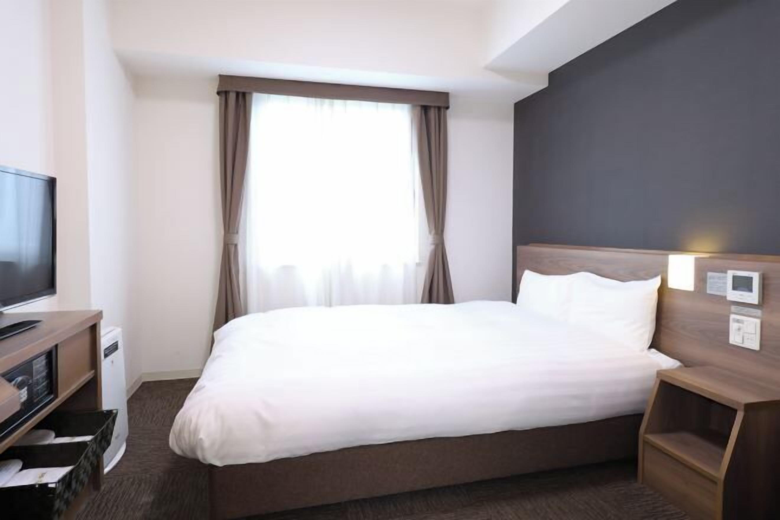 Ylelliset vuodevaatteet, untuvapeitot, tallelokero huoneessa, työpöytä