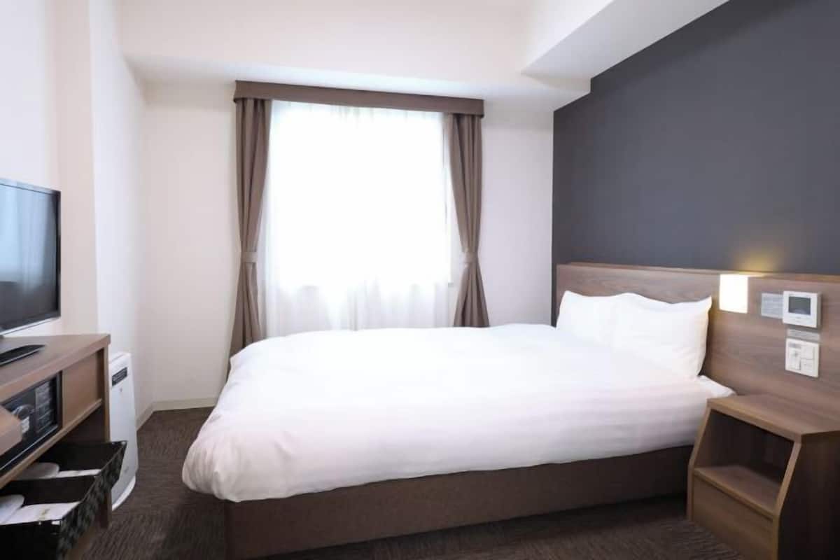 Ylelliset vuodevaatteet, untuvapeitot, tallelokero huoneessa, työpöytä