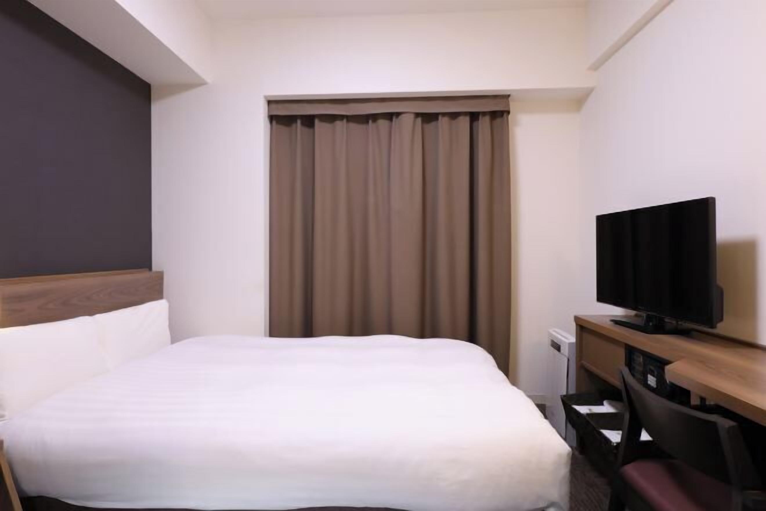 Ylelliset vuodevaatteet, untuvapeitot, tallelokero huoneessa, työpöytä