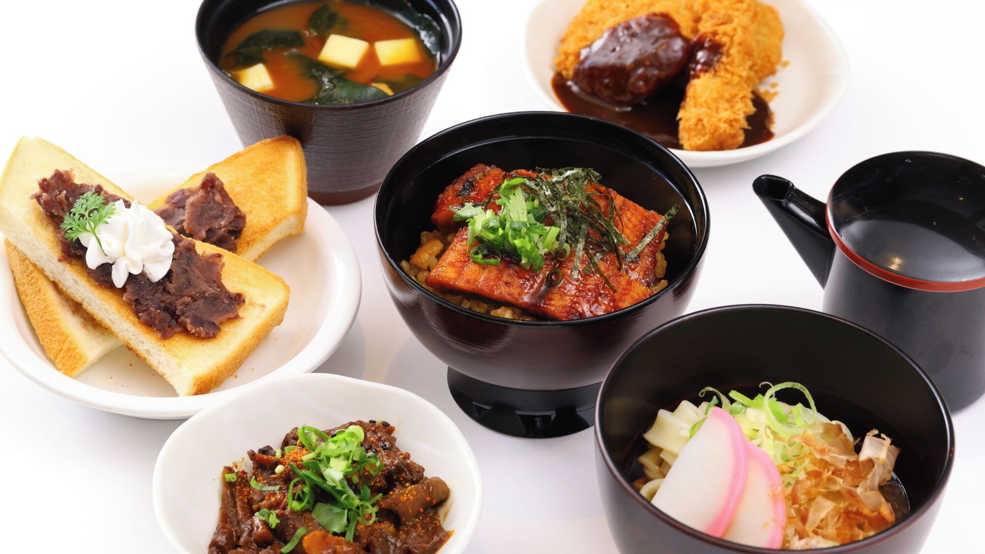 A variety of dishes including a bowl of soup, a plate with fried items, and a bowl with a red sauce.