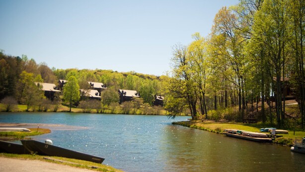 A lakeside view with boats, a dock, and houses in the background. - Country Hideaway at Mountain Lakes (Cleveland)