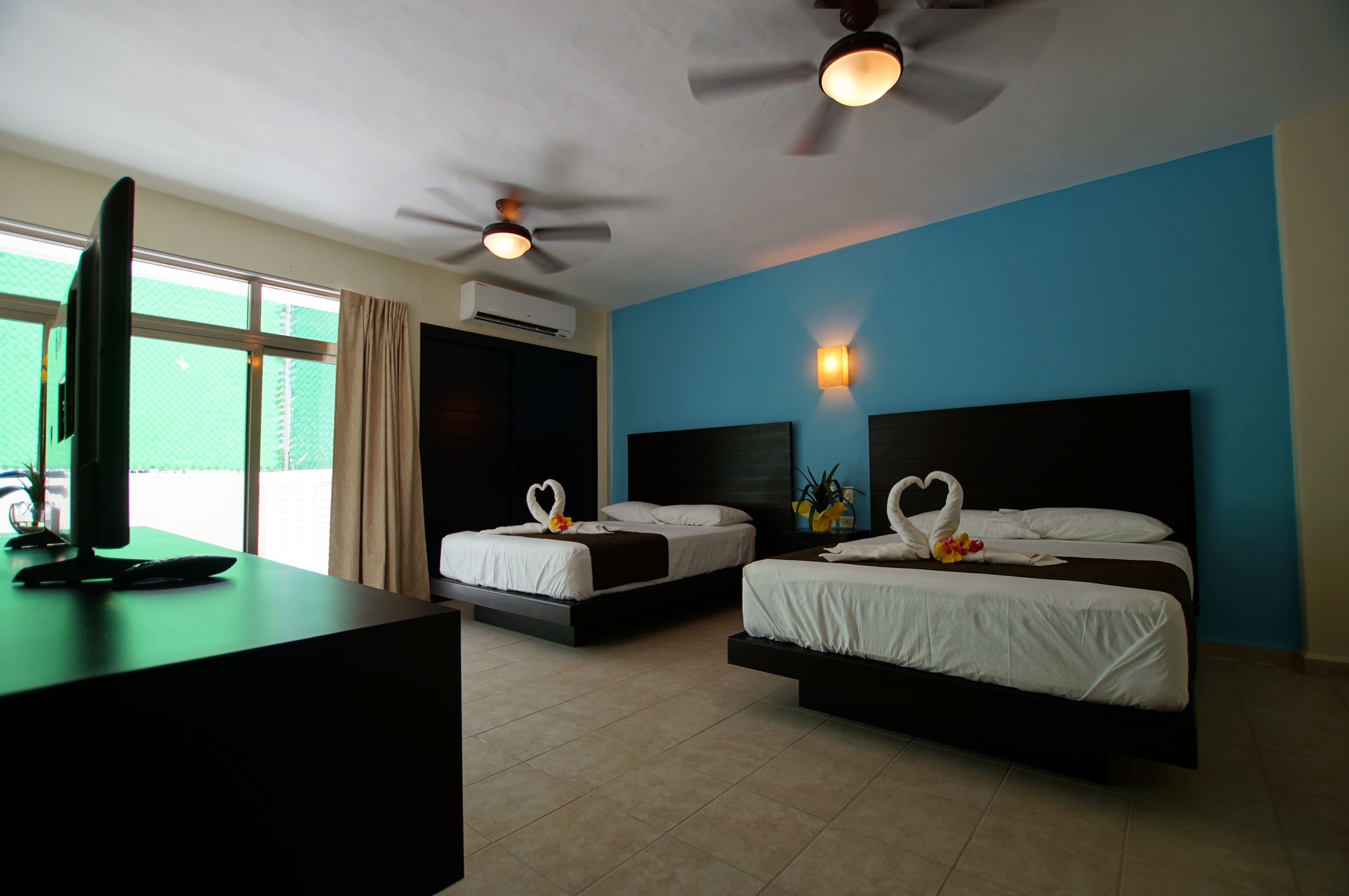 deluxe room (3 queen beds) | in-room safe, iron/ironing board, free cots/infant beds