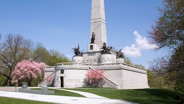 A tall obelisk monument with a statue base, surrounded by a circular platform and stairs, set in a park with trees and a clear sky. - Inn at 835 Boutique Hotel (Springfield)