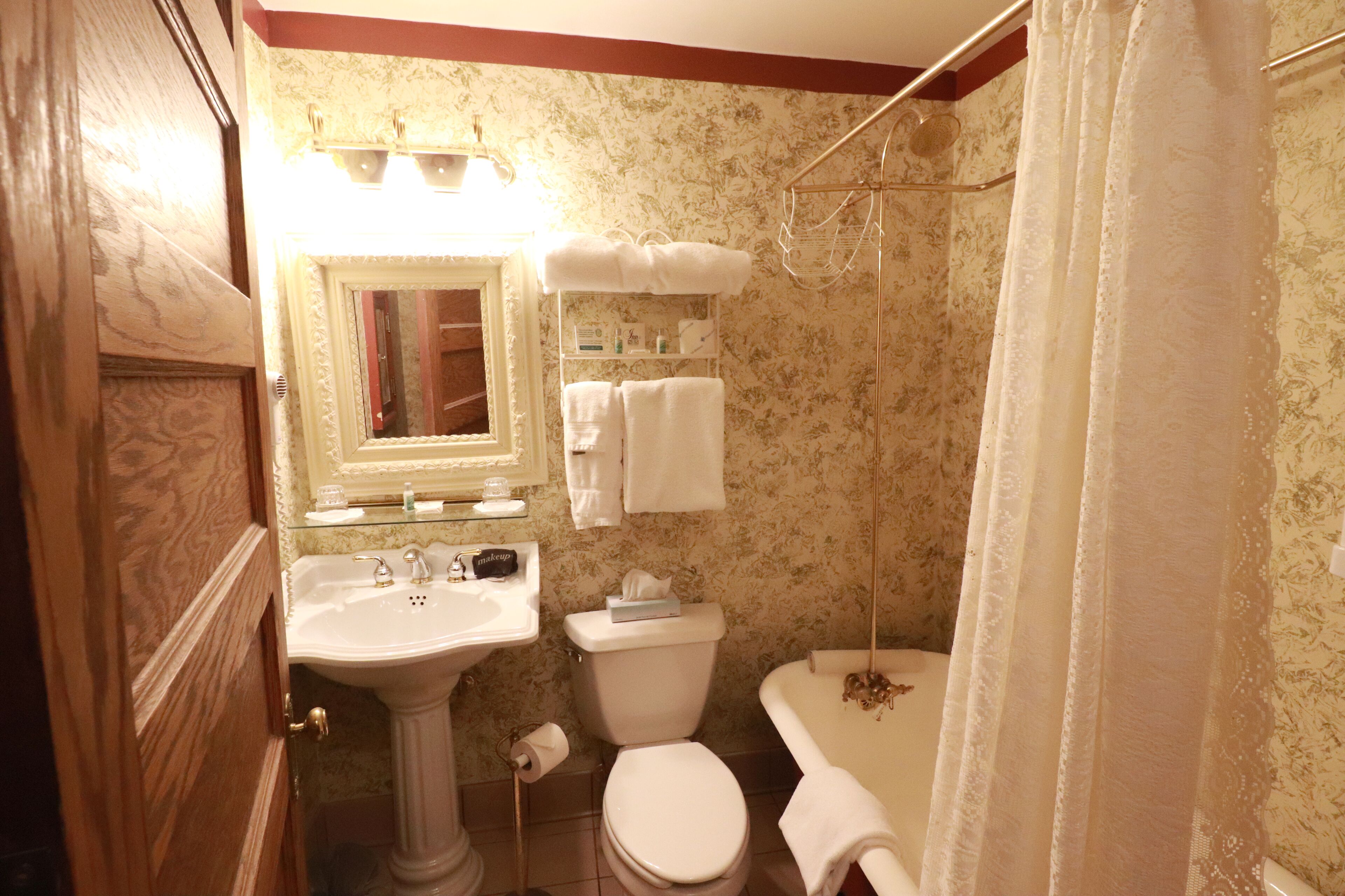Ein Badezimmer mit einem Waschbecken auf Säule, einer Toilette und einer Badewanne.