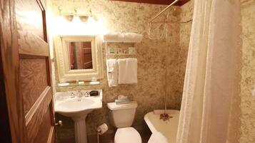 Ein Badezimmer mit einem Waschbecken auf Säule, einer Toilette und einer Badewanne.