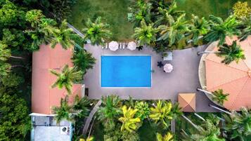 Alberca al aire libre, sombrillas en la alberca y camastros