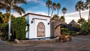 A white building with a sign reading "Select InHouse Hacienda Tres Ricos".