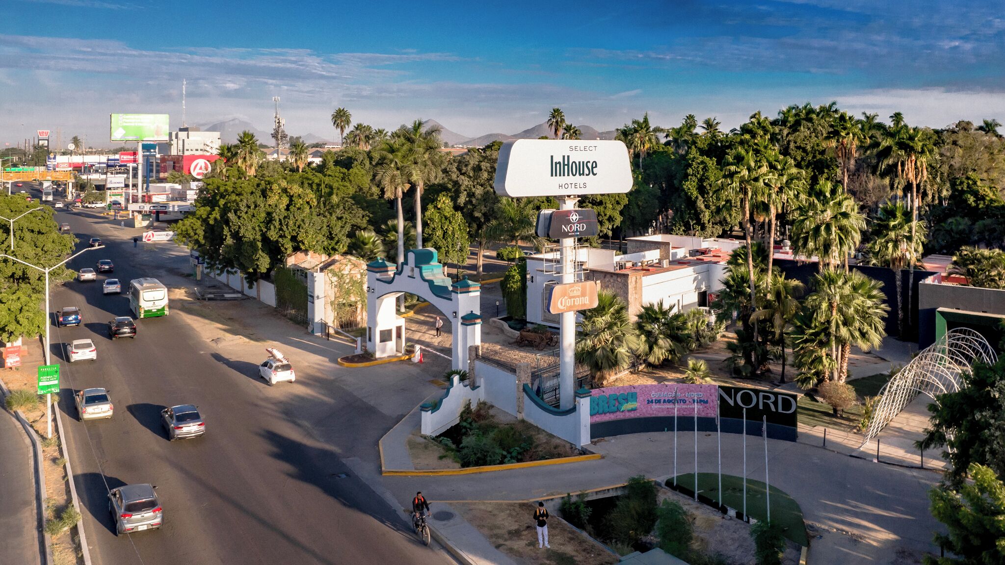 Un complejo hotelero con varias edificaciones, un letrero destacado para InHouse Hotels y un letrero Nord que indica un hotel Nord.