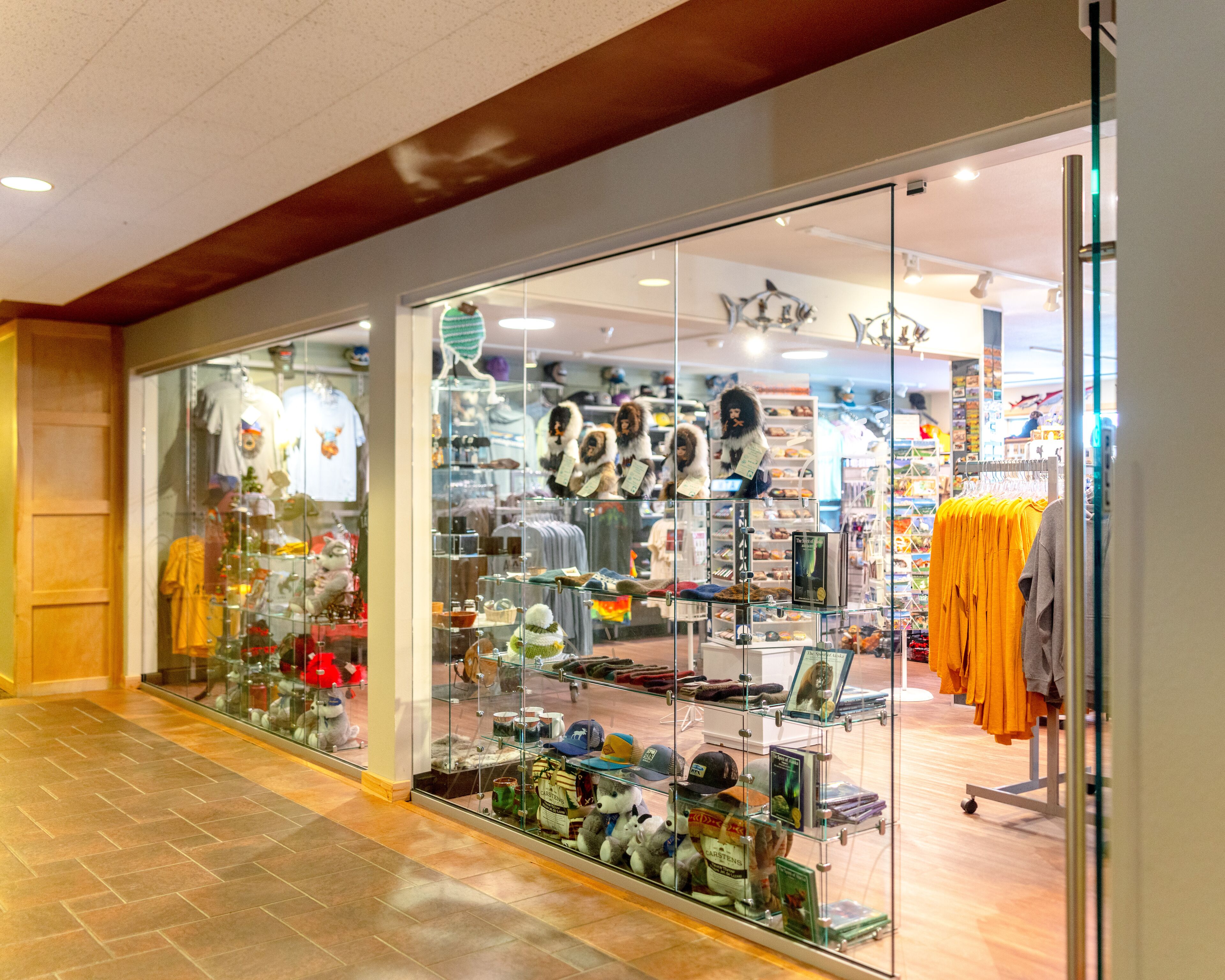 A store with glass display windows showcasing various hats and clothing items.